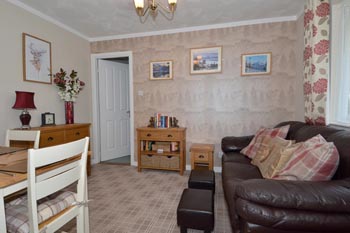 Living room with comfy three-seater sofa and flat screen TV with Freesat